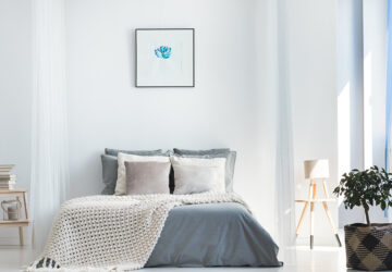 White and grey bedroom with wall art above the bed