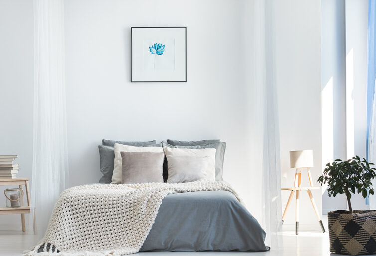White and grey bedroom with wall art above the bed