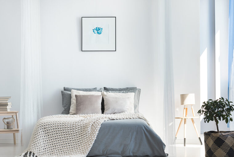 White and grey bedroom with wall art above the bed