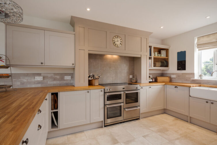 Modern Shaker style kitchen interior with fitted appliances including oak strip countertops and worksurfaces, cupboards and drawers