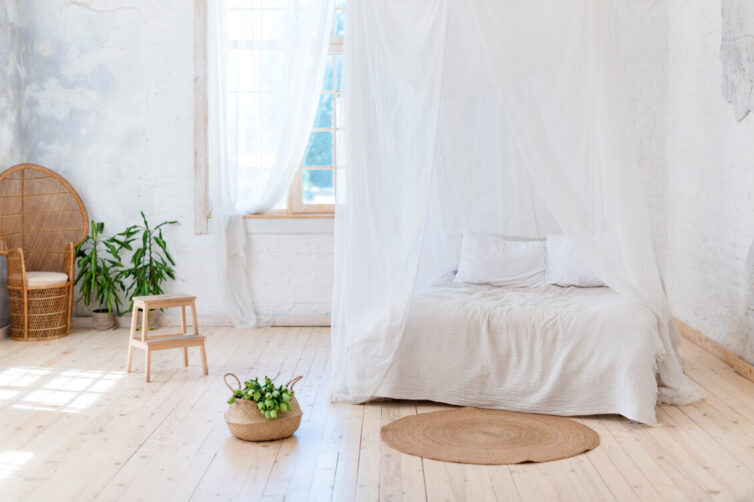 Tropical calm bedroom with four poster bed and draps. With wicker furniture and plants