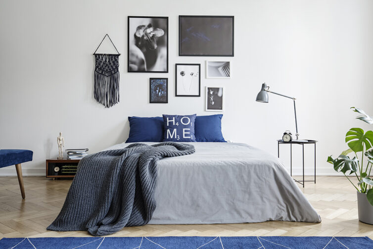 Blue and grey bedroom with black and white artwork on the wall