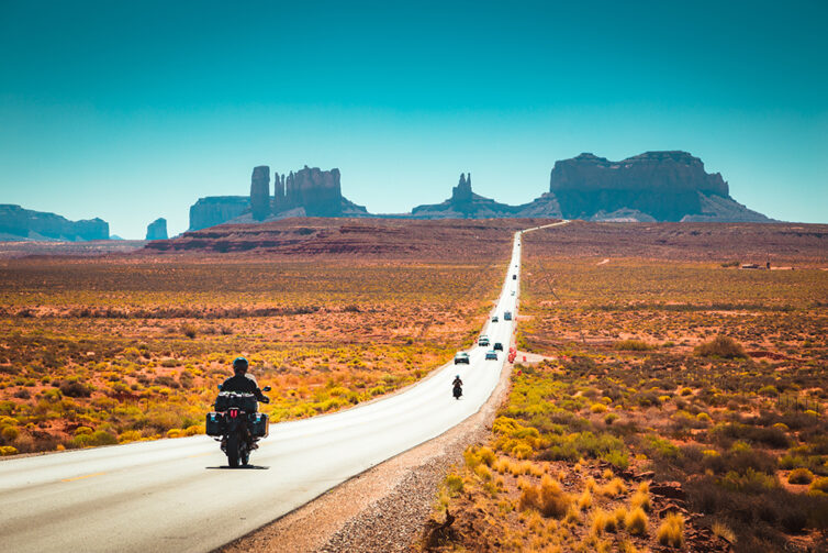 Biker on Monument Valley road at sunset, USA