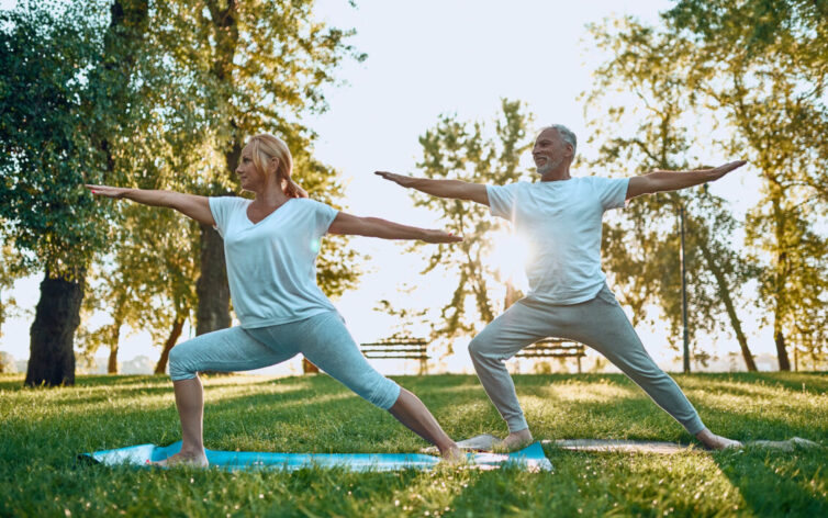 Senior couple doing yoga outdoors