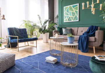 Green and blue tropical living room with plants and brass