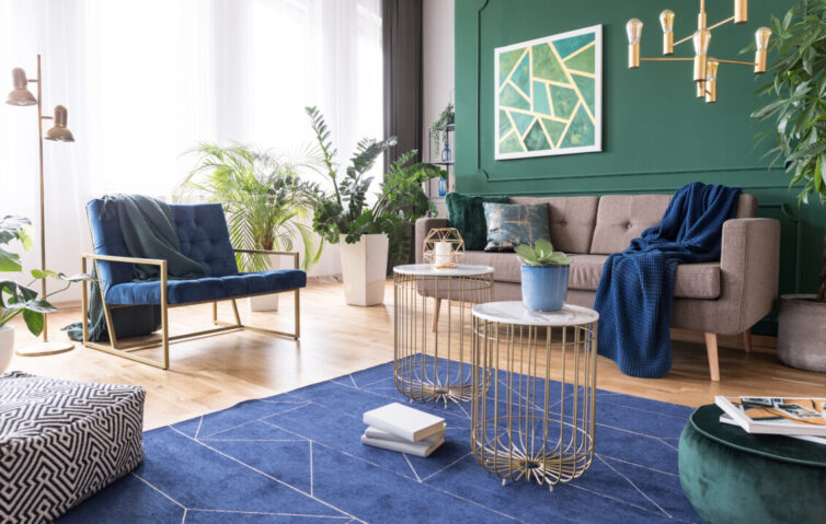 Green and blue tropical living room with plants and brass