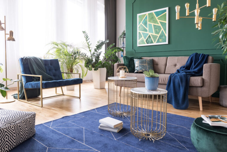 Green and blue tropical living room with plants and brass