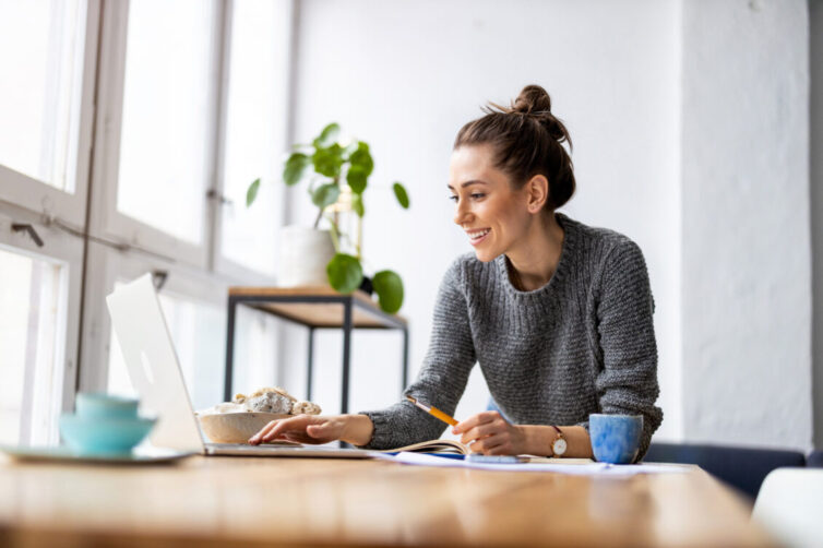 Young women sat at desk using laptop