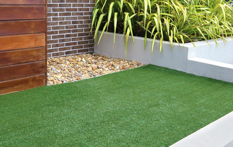 Artificial grass in modern garden with raised beds