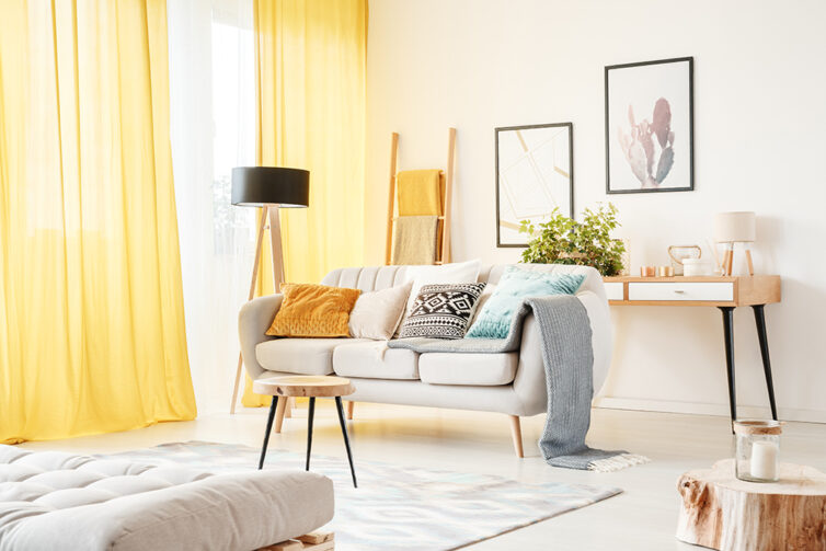 Bright fresh looking living room with yellow curtains white sofa and decorated with throws and cushions