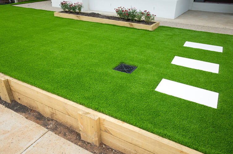 Artificial grass with concrete pathing slabs