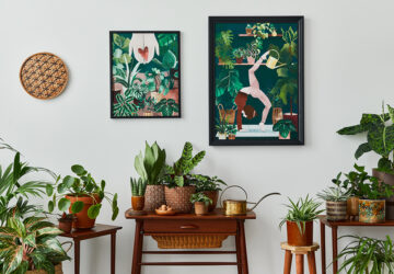 Living room with vintage retro shelf and tables with house plants, cacti. Yoga posta poster framed on the white wall.