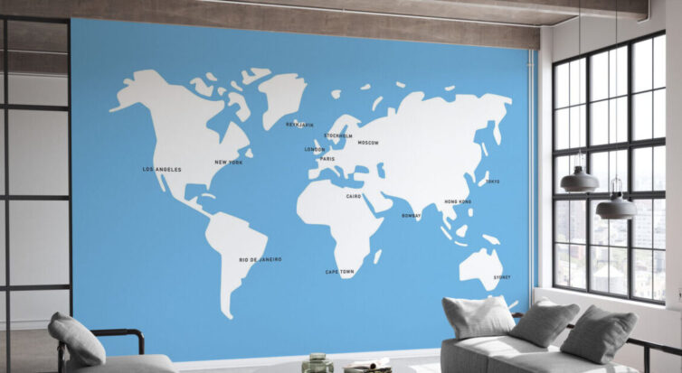 World map mural on wall of office reception area with grey sofa