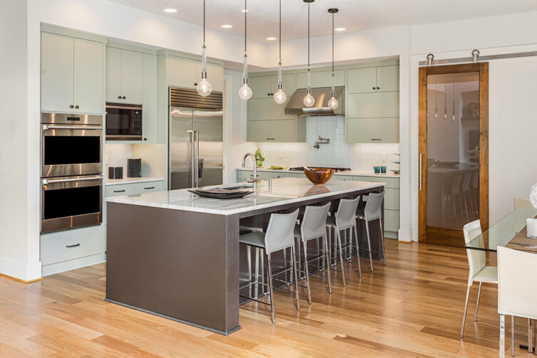 Modern kitchen with stainless steel appliances and laminate flooring