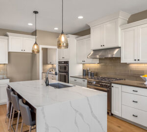 White kitchen cupboards with quartz counter tops and laminate flooring