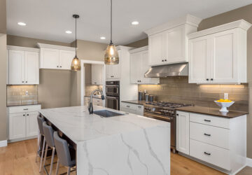 White kitchen cupboards with quartz counter tops and laminate flooring