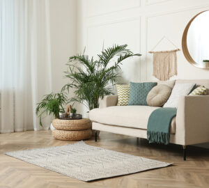 Cream sofa in a loung with plants and window net curtains