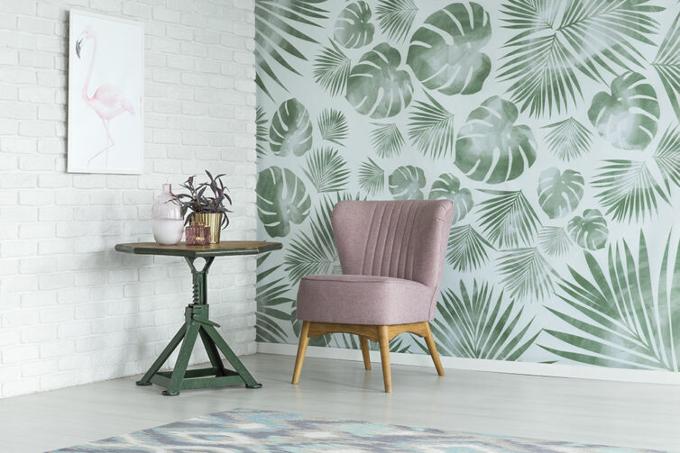 Green plant wallpaper with greyish pink slipper chair