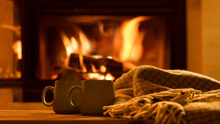 Mugs of hot chocolate by the woodburning fireplace