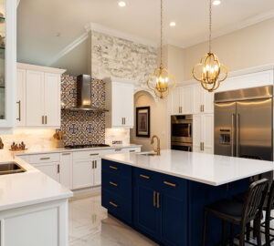 Modern White Kitchen in Estate Home. Blue kitchen island. White stone countertops