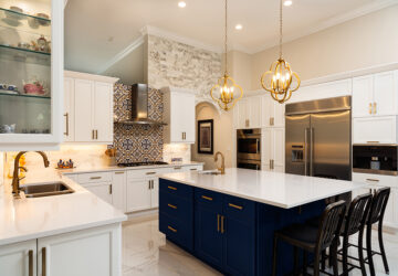 Modern White Kitchen in Estate Home. Blue kitchen island. White stone countertops