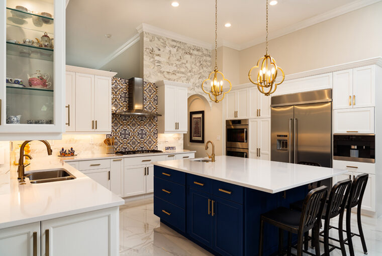 Modern White Kitchen in Estate Home. Blue kitchen island. White stone countertops