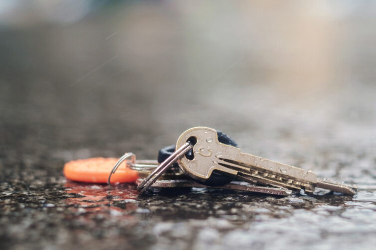 Wet pavement with set of lost keys on the ground 