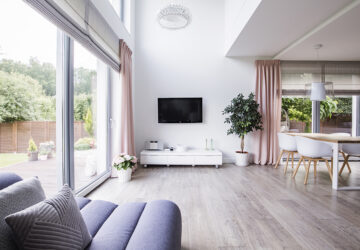 Contempory minimalist living room and open planed kitchen with grey laminate flooring