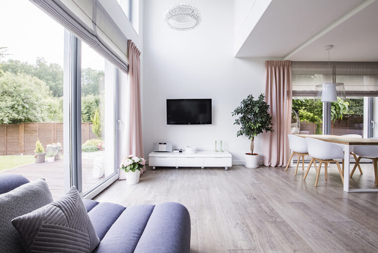 Contempory minimalist living room and open planed kitchen with grey laminate flooring