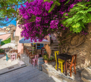 Street with cafe table and chairs. Flowers in bloom in Capoliveri village in Elba island, Tuscany, Italy, Europe