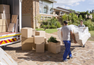 Removal company delivering sofa and boxes to new home with box van