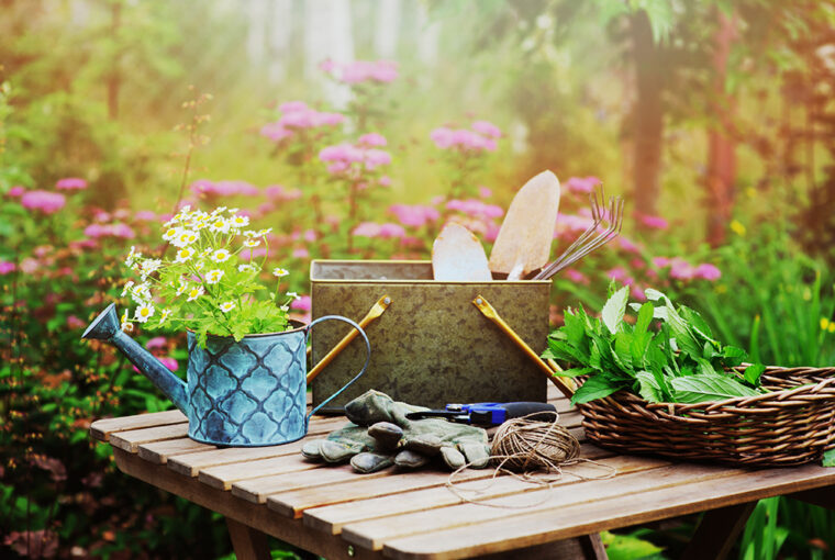 Garden table with watering can, gardening gloves and gardening tools