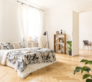 Large light bedroom with wooden Herringbone flooring