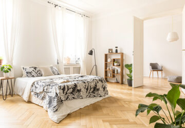 Large light bedroom with wooden Herringbone flooring