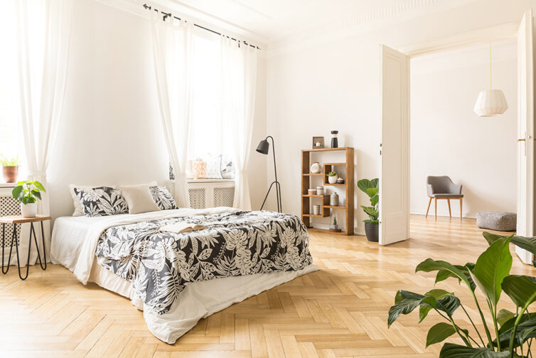 Large light bedroom with wooden Herringbone flooring