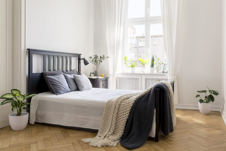 Bright bedroom with large window and wooden Herringbone pattern flooring