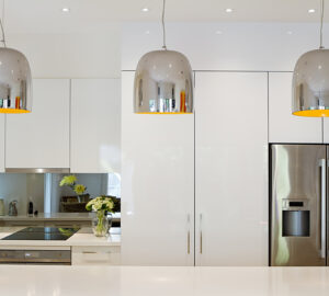 Modern Kitchen with mirrored splashback and metal light pendents