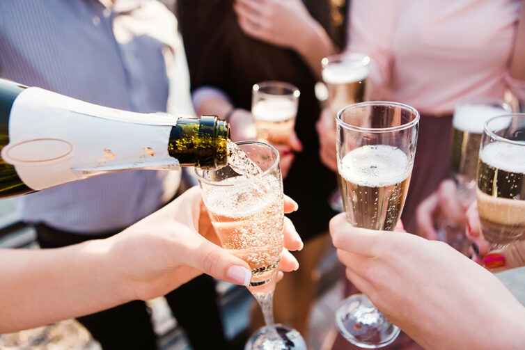 Pouring champagne into glasses.