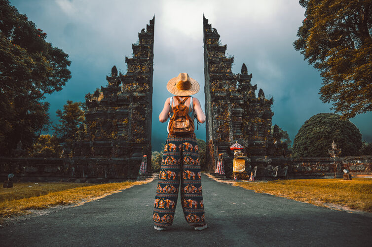 Woman traveller posing in front of a temple in Asia
