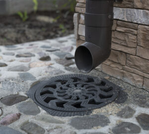 Dark coloured drain pipe leading to drain cover fitted into the ground