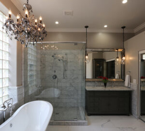 Luxury bathroom with roll top bath, walk in shower and chandelier