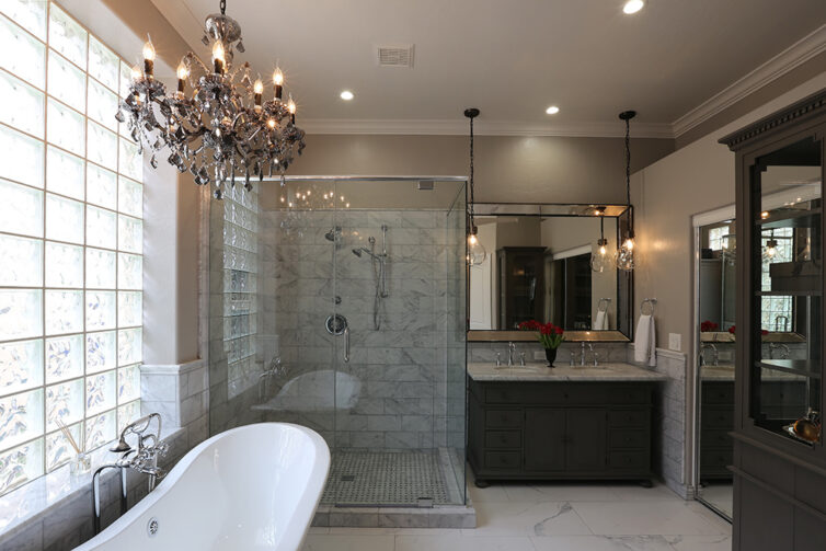 Luxury bathroom with roll top bath, walk in shower and chandelier