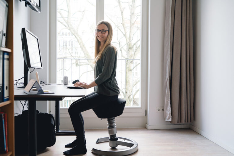 Women in home office sat on backless egonomic office chair