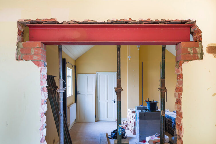 Wall knocked down between two rooms. Large steel mantel placed in wall.