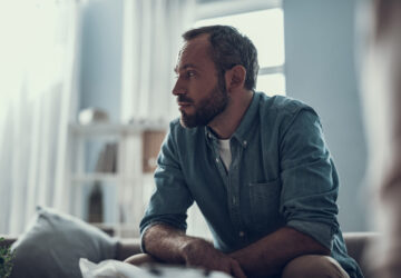 Man sat down looking worried