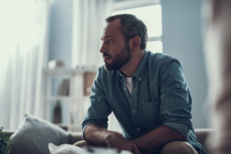 Man sat down looking worried