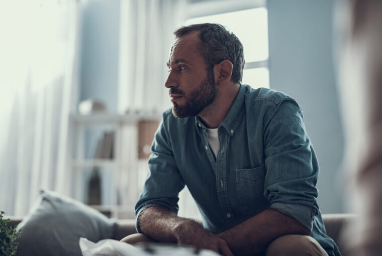 Man sat down looking worried