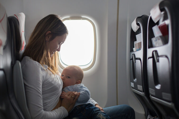 Young mum feeding baby on plane