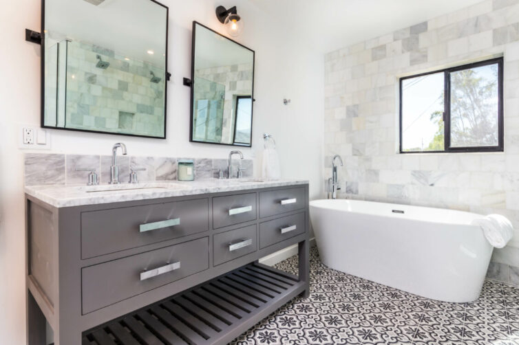 Grey and white modern bathroom with double sink, square bathroom mirrors and stand alone bath tub