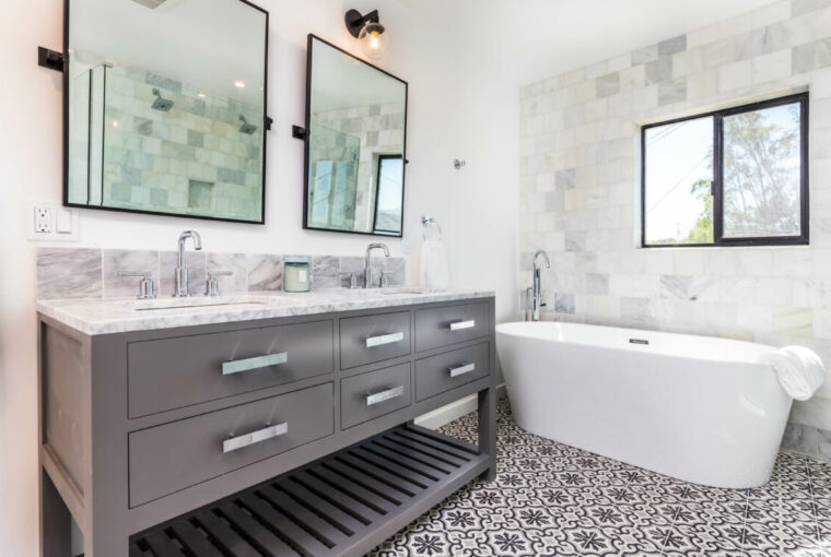 Grey and white modern bathroom with double sink, square bathroom mirrors and stand alone bath tub